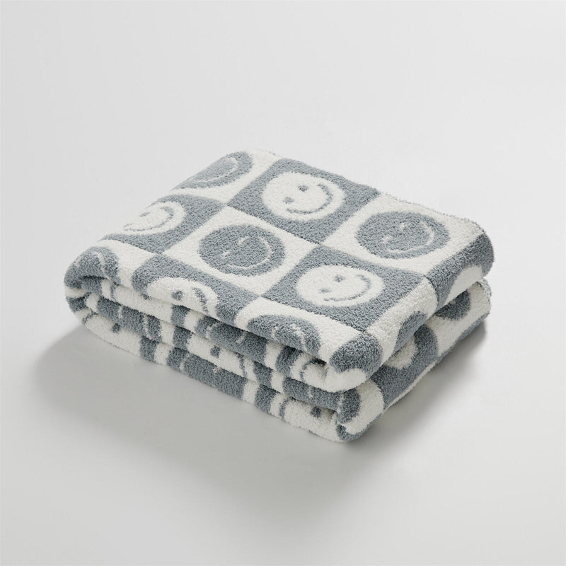SnuggleJoy – Hyggeligt tæppe med ternet mønster og smil emoji design